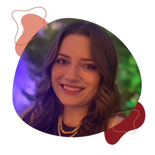 Lynora smiles for a photo with green plants and purple lights in the background